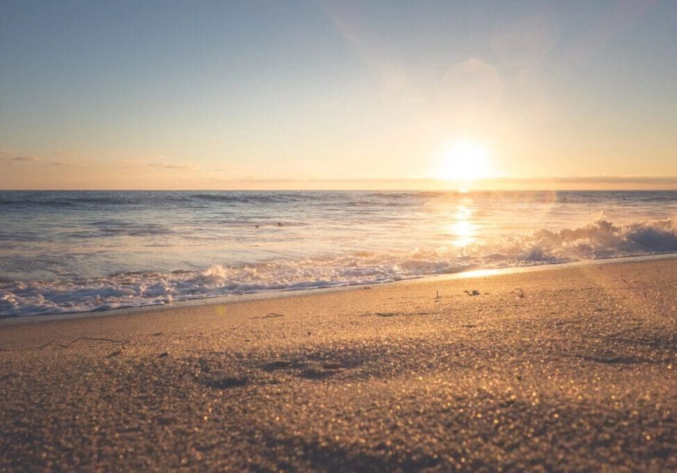Sunset over a tranquil sandy beach.